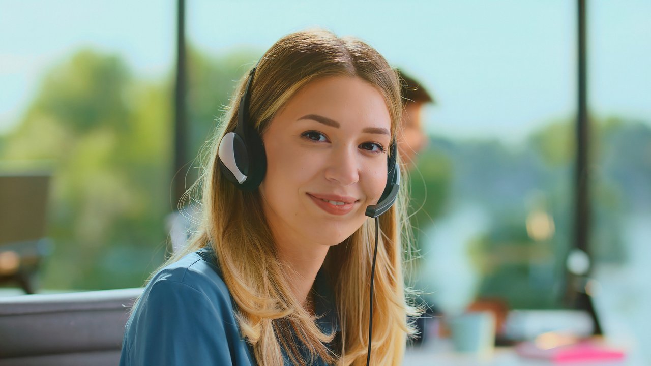 Asesora sonriente con auriculares de atención al cliente